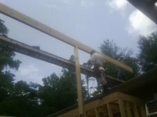 Carpenter setting a ridge beam over a new addition frame — Ice Dam Removal by Roofing Brothers in North Plains
