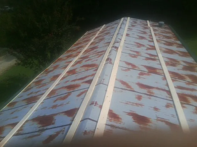 Rusted metal roof panels with new wood purlins before replacement — Storm Damage Roof Repair in North Plains by Roofing Brothers