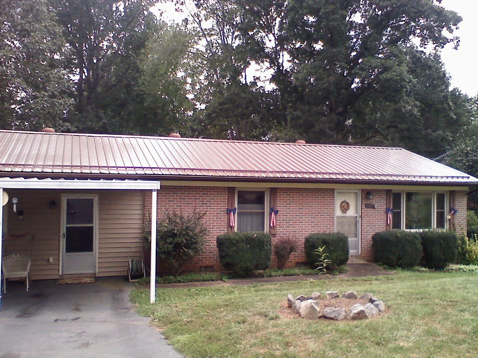 Bronze metal roof and carport on a brick ranch home — Roof Repair work by our crew in North Plains